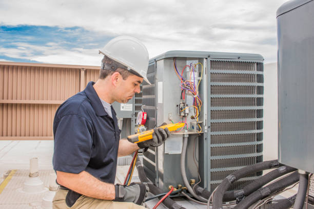 AC technician working on condenser unit.